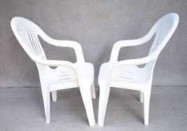 Two White Plastic Stacking Patio Chairs