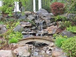 Garden Pond And Waterfall With Bridge