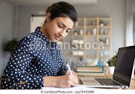Smart indian girl make notes studying on laptop at home. Smart indian girl  sit at desk in living room handwriting in notebook | CanStock