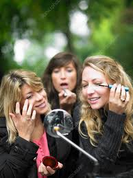 women applying makeup in car mirror