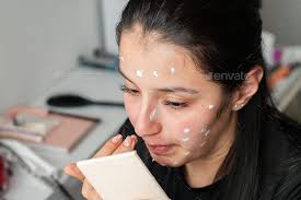 young latina woman applying moisturizer