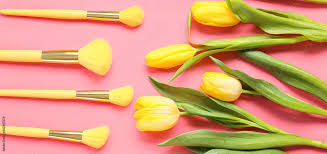 makeup brushes and yellow tulip flowers