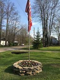 A flag pole and custom flag will mark you tailgating spot with distinction. 17 Best Flag Pole Landscaping Ideas Flag Pole Landscaping Flag Pole Backyard Landscaping