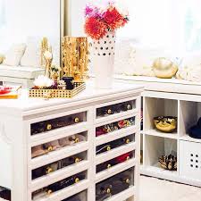 White lacquer closet island drawers featuring black velvet sunglass holders organized and showcased to perfection. Glam Closets Design Ideas