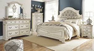 The bed boasts muted silver accents, fancy fluted pilasters, and sturdy french bracket foot bases. Ashley Furniture Realyn Bedroom Collection
