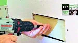 While holding it try to get a screw. How To Attach Drywall On A Drywall Repair When Theres No Wood Youtube