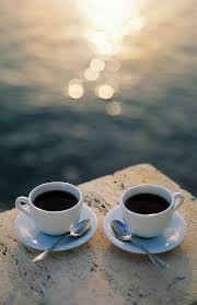 two cups of coffee by the ocean at