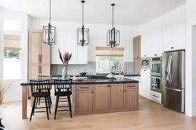 Featuring a wide open floor plan, this kitchen is highlighted by cupboard doors on every usable surface, including the matching refrigerator. Kitchen Trend Wood Stained And Painted Cabinets Home Bunch Interior Design Ideas