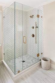 Finish the design by using basic, white subway tiles to frame the focal wall. Master Bathroom Shower With White Herringbone Tiles And Gray Grout Features Perfect Di Budget Bathroom Remodel Patterned Bathroom Tiles Modern Bathroom Remodel
