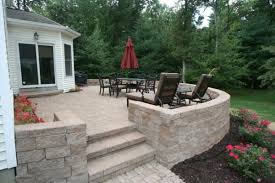 Blend Your Raised Patio Against The House With A Retaining Wall Frame And Plantings
