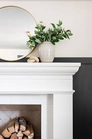 Round Brass Mirror Over White Fireplace