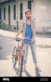 young hipster gay man with bike in the city Stock Photo - Alamy