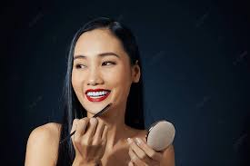 makeup artist applies red lipstick on