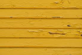 Wall Of An Old Bright Yellow Barn