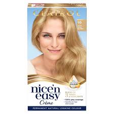 Happy woman sitting on sofa. Nice N Easy Permanent Colour 103 Natural Light Beige Blonde Hair Dye Morrisons