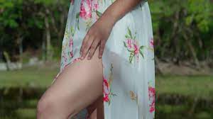 Premium stock video - Ascending camera movement of a young latina exposed  sexy legs while wearing a flower dress