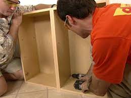 After the filler strip is clamped to the cabinet, use the guide bushing and a long 1/8″ drill bit to drill a pilot hole into the filler. How To Install Wall And Base Kitchen Cabinets How Tos Diy