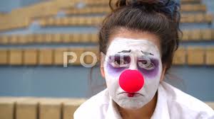 sad clown with white face and red nose