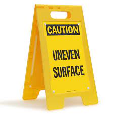 caution uneven surface floor sign
