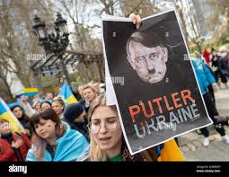 10 April 2022, Hessen, Frankfurt/Main: "Putler Ukraine" is written on the  poster under a head, which is supposed to represent a mixture of Hitler and  Putin, displayed at a demonstration directed against