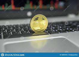 Golden Ripple Coin On A Black Keyboard Of Silver Laptop And