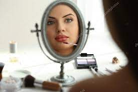 beautiful young woman looking in mirror