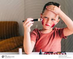 boy applying makeup on face in house