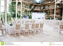 Awesome Wedding Hall With White Chairs And Purple Flowers On