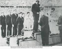 He invented the game of basketball in 1891, and he is also credited with designing the first football helmet. Dr James Naismith Presents The Gold Medals To The Us Basketball Team In The 1936 Olympic Games At Berlin Germany Basketball Teams Kansas Basketball Kansas