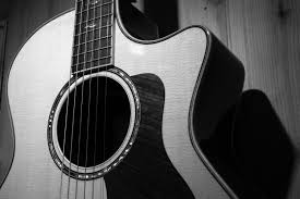 acoustic guitar in grayscale photo