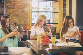 Happy Teenage Girls Talking And Laughing In A Cafe Stock Photo - Download Image Now - iStock