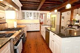 modern farmhouse kitchen with white cabinets blue pearl silver granite and wide plank hardwood flooring floor