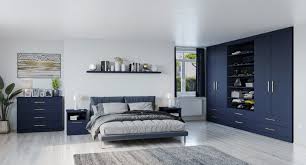 A bedroom filled with elegance with its furniture sets and warm lighting. Blue Fitted Wardrobes Modern Bespoke Furniture