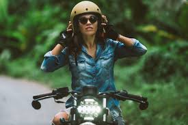 female biker driving a cafe racer motorbike