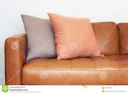 Close Up Of Tan Leather Sofa With Linen Cushions Stock Photo