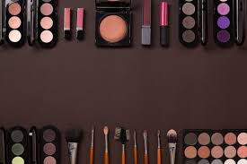 various cosmetics and brushes on brown