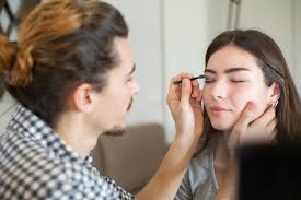 a man putting makeup on a woman free