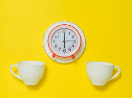 A Red Alarm Clock On A Saucer And Two