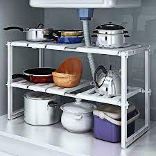 How should pots and pans be stored beneath the sink?