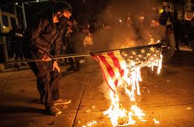 Cops declare riot in Portland as Antifa and BLM protesters smash shop windows after march 'against capitalism'