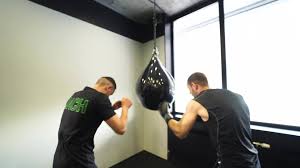 man at boxing gym jabs at punching bag