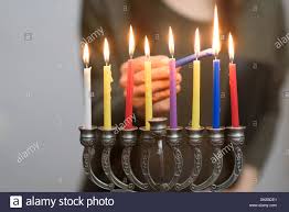 Jewish Woman Lighting Hanukkah Candles In A Menorah People