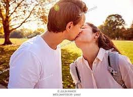 young couple in love kissing in a park