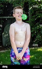Shirtless preteen caucasian boy about to be hit with a water balloon Stock  Photo - Alamy