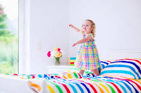 girl jumping on a bed stock photo