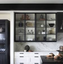 Black painted window frames, white subway tile and a checkerboard floor play off new brass hardware on the cabinets in this neutral kitchen. 21 Black Kitchen Cabinet Ideas Black Cabinetry And Cupboards
