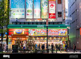 Tokyo, Akiharbara. Tax Free shop, Akky II and Melonbooks on Chuo-dori, the  main shopping area with tourists, people outside during blue hour, evening  Stock Photo - Alamy