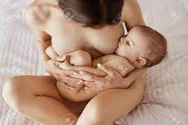 Young Beautiful Naked Mom Breastfeeding Hugging Her Newborn Baby Smiling  Sitting On Bed At Home. Stock Photo, Picture and Royalty Free Image. Image  81214919.