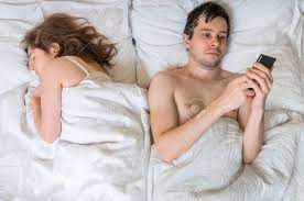 Young Man Is Texting With Someone Using Phone While His Wife Is Sleeping  Near Him. Cheating Concept. Stock Photo, Picture and Royalty Free Image.  Image 71601296.