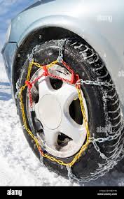 Snow chains mounted on car wheels on winter day Stock Photo - Alamy